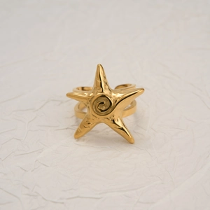 Detailed close-up of a 18k gold plated starfish ring with double band on white texture