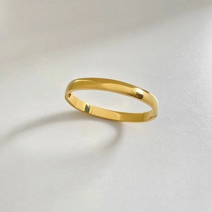 Detailed view of a polished gold minimalist stainless steel bangle with a secure clasp