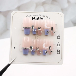 Detailed view of handmade press-on nails with purple gradient and star-moon crystals