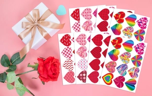 Luminous heart stickers with various patterns next to a gift box and red rose