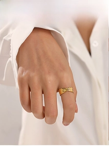 Vista dettagliata di un anello dorato a corda intrecciata indossato per un look alla moda