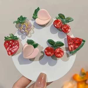 Detailed set of 7 colorful fruit-shaped hair clips including cherry and strawberry designs