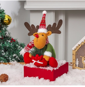 Detail of Christmas reindeer plush toy with knitted hat on a festive holiday background