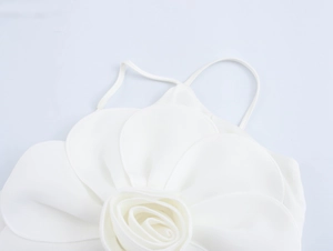 Close-up of elegant 3D floral decoration on white camisole top with thin straps