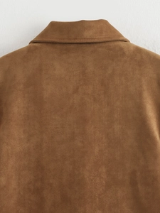 Gros plan du dos d'une veste en daim marron montrant la texture et le col