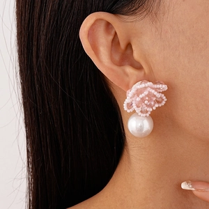 Pink beaded flower earrings with white imitation pearl drop shown on a model