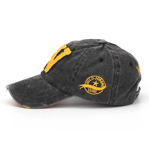 Macro shot of distressed wash cotton baseball cap with yellow V patch and vintage embroidery