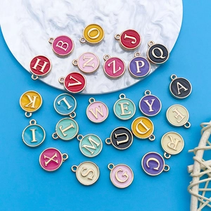 Colorful A-Z enamel alphabet charms for DIY jewelry making on white marble tray