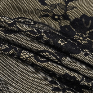 Macro shot of elegant black floral lace fabric with nude underlay on mini dress