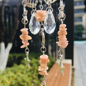 Detailed butterfly suncatcher with crystal pendants and pink stones against outdoor background