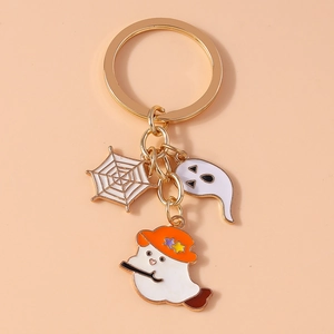 Detail of Halloween charms with white ghost, witch hat ghost and gold spider web
