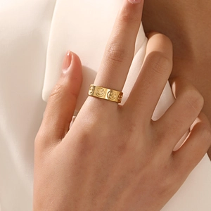 Fashionable gold plated wide band titanium ring featuring a minimalist smiley face design