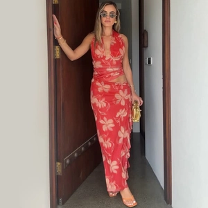 Détails de la robe longue rouge à imprimé fleuri avec licou et découpes à la taille