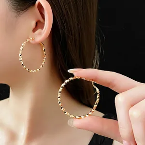 Orecchini a cerchio dorati irregolari con finitura geometrica diamantata per donna