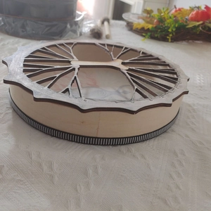 Detailed close-up of a wooden storage box with an intricate tree of life cutout lid