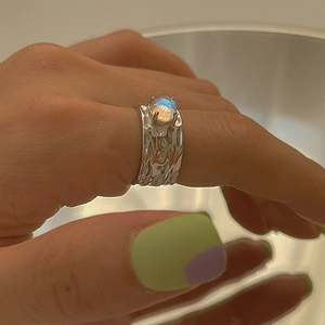 Macro detail of irregular lava texture ring with blue fire moonstone in silver finish