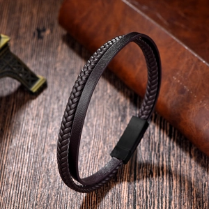 Close-up of dual-layer leather bracelet with a magnetic clasp on a rustic wooden desk