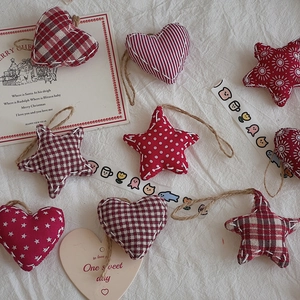 Flat lay of red and white fabric Christmas ornaments with heart and star patterns