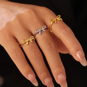 Bow tie knot minimalist rings in gold and silver finish on hand model