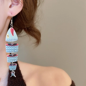 Detail of blue fish-shaped earring with ethnic patterns and five-segment tassel structure