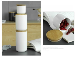 Stack of white ceramic storage jars with bamboo lids showing various sizes in a kitchen