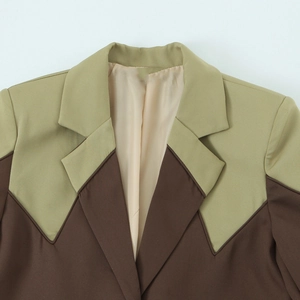 Close-up of olive and brown color-block blazer collar showing refined stitching detail