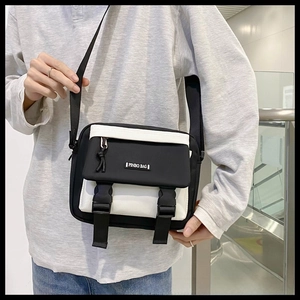 Detail of vintage messenger bag featuring black and white contrast and dual buckle closure