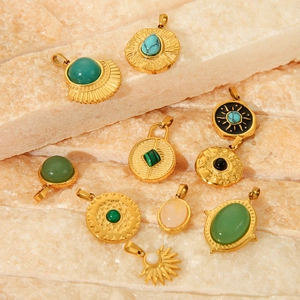 Flat lay of vintage gold titanium pendants with colorful natural stones on stone texture