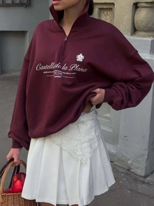 Retro deep red half-zip sweatshirt with white print on vintage street background