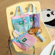 Close-up of colorful mesh handbags and cartoon coin purses displayed on a yellow chair