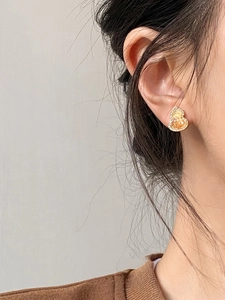 Detailed view of gold-plated gourd earrings with shimmering cubic zirconia inlay