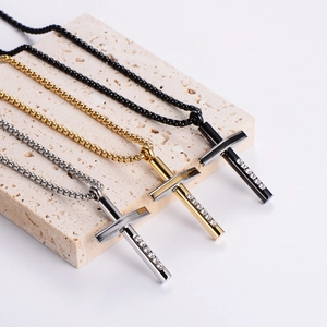 Diamond-encrusted cross pendant necklaces in gold, silver, and black on a stone base