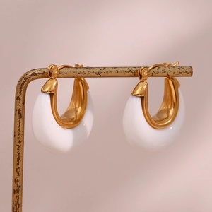 U-shaped hoop earrings with white enamel finish on a vintage gold display stand