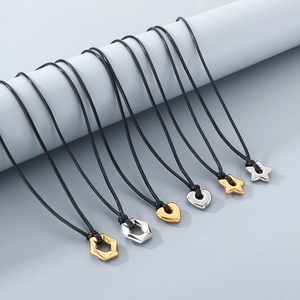 Close-up of gold and silver hollow star, heart, and hexagon pendants on black nylon ropes
