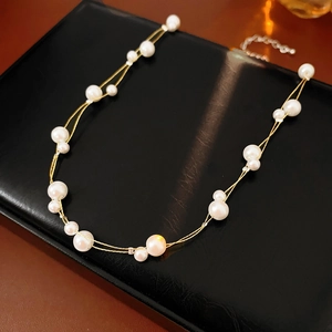 Détail macro d'un élégant collier de perles double épaisseur avec chaîne dorée et fermoir