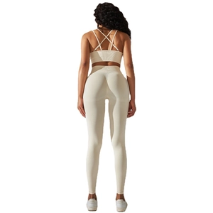Women's cream ribbed yoga set featuring cross-back sports bra and high-waist leggings