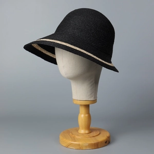 Detail of black woven raffia sun hat with cloche dome and light brown decorative band