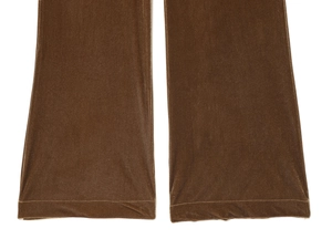 Gros plan détaillé de la jambe de pantalon en velours marron montrant le tissu et l'ourlet