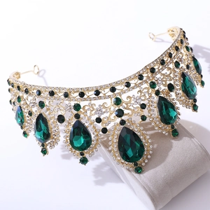 Detail of bridal crown with emerald teardrop stones and rhinestones on a golden base