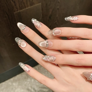 Pink cat eye press-on nails with handmade floral patterns and pearl rhinestones