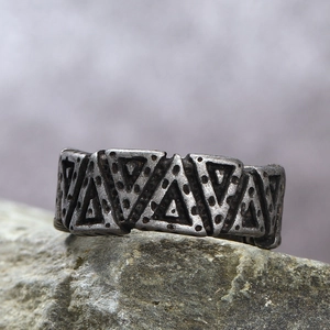 Nordic Viking vintage triangular relief steel ring on stone background
