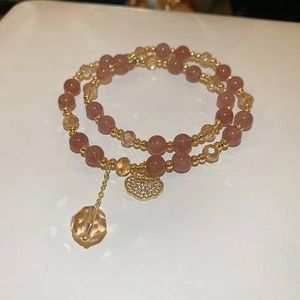 Detail of pink strawberry crystal wrap bracelet with golden Ruyi lock and crystal charms