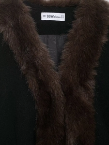 Detail shot showing the BBWMWOMAN brand label and soft faux fur collar on the coat neck