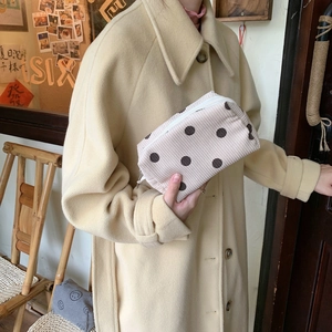 Detail of vintage beige corduroy cosmetic bag with brown polka dots and zipper texture