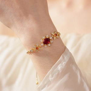 Details eines Vintage-Goldarmbands mit Rubinmitte und Zirkonia-Blumen am Handgelenk