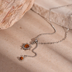 Close-up of vintage sunflower pendant with faux tiger eye stone on silver chain