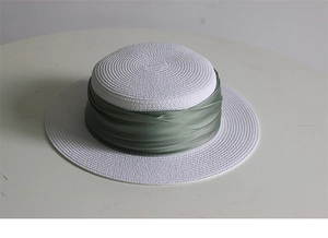Close-up of fine white straw weave and olive green satin ribbon on French sun hat