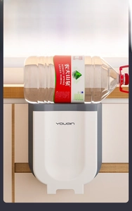 Foldable wall-mounted kitchen waste bin showing strong weight-bearing capacity in use