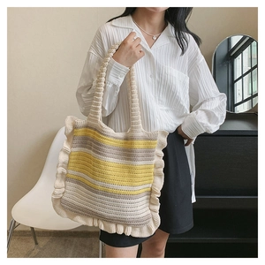 Detail of striped knitted shoulder bag with beige base and yellow ruffled edges