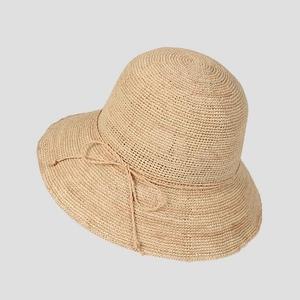 Detail of the woven texture and bow accent on the summer raffia straw sun hat